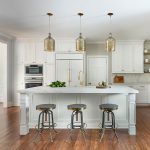 white mouser cabinets in a remodeled kitchen with gold accents